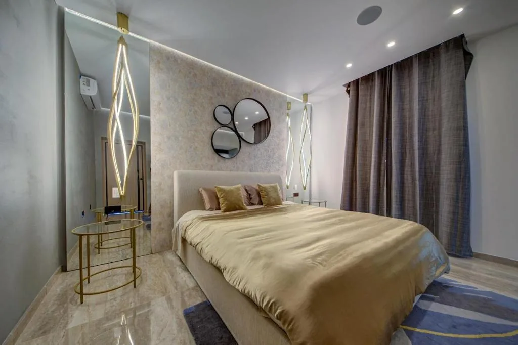 A bedroom with mirrored wall and hanging lights