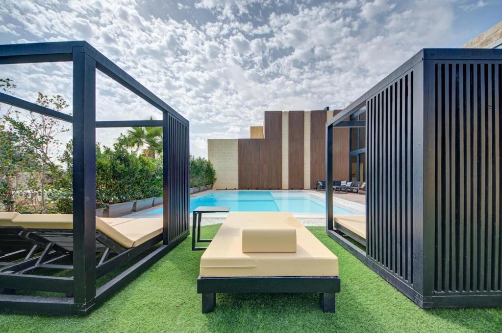 Slatted cabanas and day beds on the grass beside the water