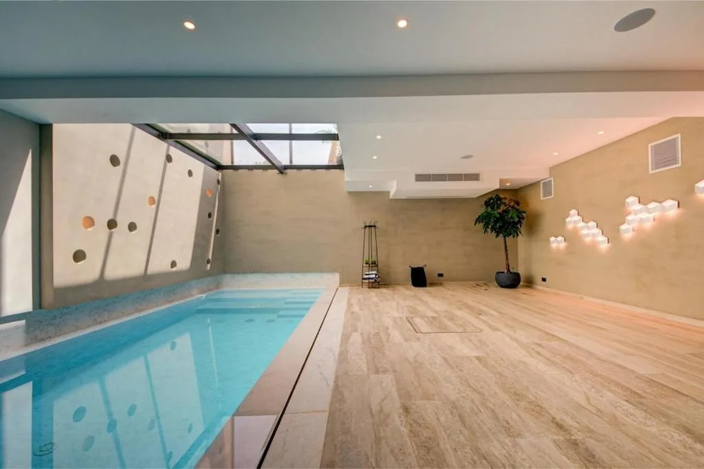 The indoor lap pool beneath its skylight and perforated wall