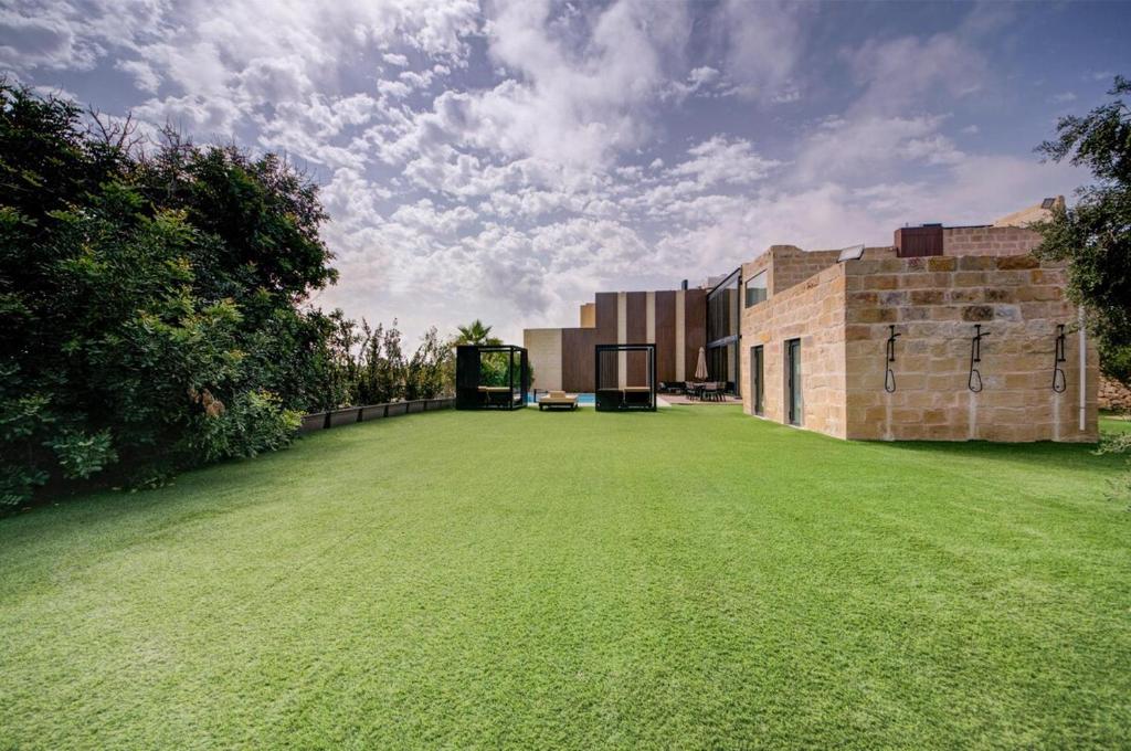 The lawn running the length of the house to the boundary wall