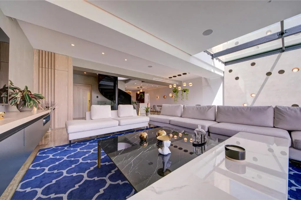 The second living room, marble and glass under a long skylight